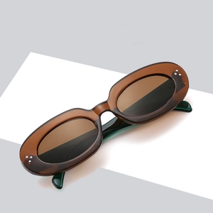 Retro oval sunglasses with amber tortoiseshell frames and dark lenses with metal studs