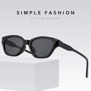Minimalist black cat eye sunglasses for women on a stylish white geometric stand