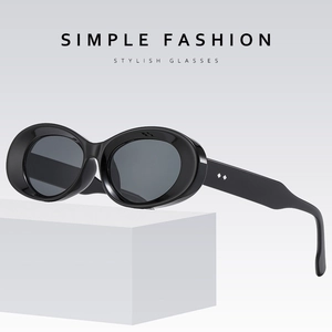 Retro oval black frame sunglasses with dark grey lenses on a minimalist white pedestal
