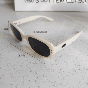 Macro shot of vintage cream oval sunglasses with silver rivets and black lenses