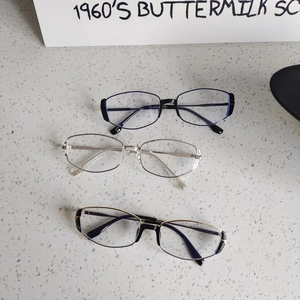 Vintage cat eye sunglasses in black, silver, and gold metal frames on stone background
