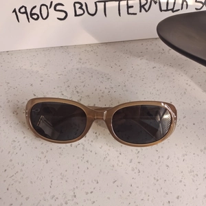 Detail view of vintage amber translucent oval sunglasses with metallic dot accents