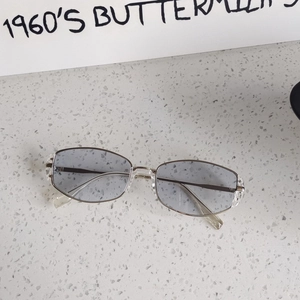 Detail shot of vintage cat-eye sunglasses with gray-blue lenses on a textured surface