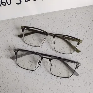Detail of olive and grey semi-rimless frames on stone surface showing metal lower rims