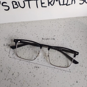 Detail view of half-rim glasses with black browline and silver frame on a stone table