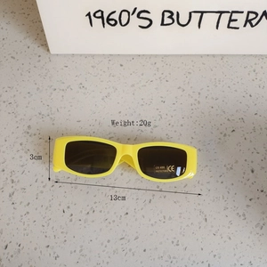 Detail of yellow rectangular kids sunglasses with UV400 protection sticker and plastic frame
