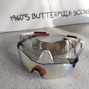 Detail of cycling glasses showing white frames and rainbow mirrored lenses for outdoor sports