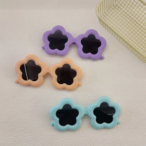 Three flower-shaped kids sunglasses in purple, orange, and blue colors