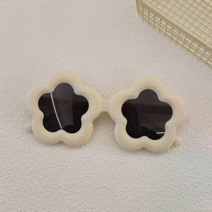 Detailed top view of cream floral children's sunglasses with dark protective lenses