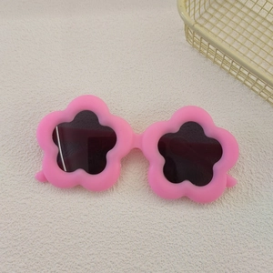Detail of pink flower-shaped frame and dark lenses on children's fashion sunglasses