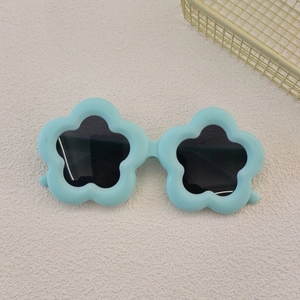 Detailed view of kids flower-shaped sunglasses in light blue with dark lenses