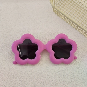 Close-up of pink flower shaped kids sunglasses with dark UV protection lenses