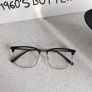 Detail view of classic black browline glasses frames with metal bridge on stone surface