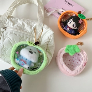 Detailed view of plush fruit-shaped bags with clear windows for displaying dolls