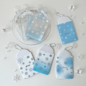 Detail of snowflake PVC card holders with metal bead chains in a winter themed display