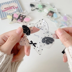 Detail of star-shaped clear acrylic photocard holder with wings and metal bead chain