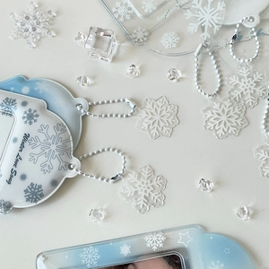 Detail of clear acrylic photocard holder with winter snowflake patterns and ball chain