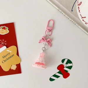 Pink Christmas tree keychain with resin charm and metal lobster clasp on a festive desk
