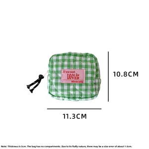 Detail of green checkered quilted cotton makeup pouch showing 11.3cm x 10.8cm dimensions