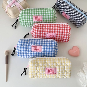 Detailed view of heart-quilted pencil cases in five colors with decorative zip pullers