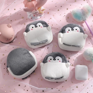 Plush penguin coin purse showing storage capacity for earbuds with zipper detail