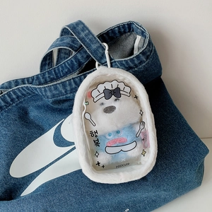 Detail of white plush doll display bag with clear PVC window and blue bear charm
