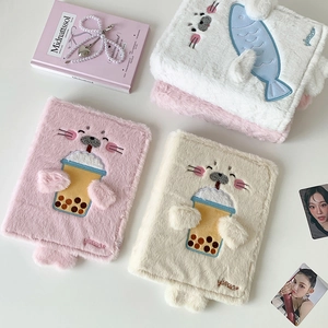 Detailed close-up of fluffy plush seal binder covers with intricate animal embroidery