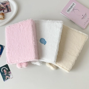 Detail of plush seal photo albums with fish embroidery in pink white and beige colors