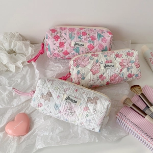 Close-up of quilted floral makeup bags with soft texture and hisocute woven label