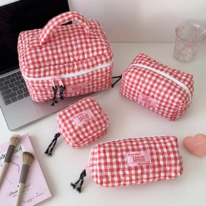 Red checkered quilted cosmetic bag set featuring a handle and heart pattern texture