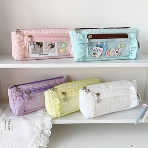 Quilted pastel pencil cases with ruffle trim and transparent card slot displayed on shelf