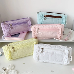 Macro view of five pastel pleated pencil cases with star zippers and PVC windows
