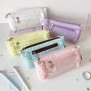 Close-up of pastel stationery pouches featuring ruffle texture and star metal zipper pulls