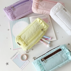 Detailed top view of pastel ruffled stationery pouches with star zippers in five colors