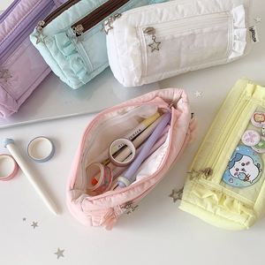 Detailed view of pleated multi-layer pencil pouches in pastel colors with star zippers