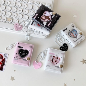 Close-up of heart-shaped hollow photo albums in black and pink with metal keychains