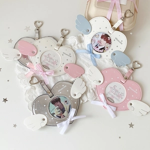 Macro detail of heart-shaped photo card holders with wings and heart metal clips