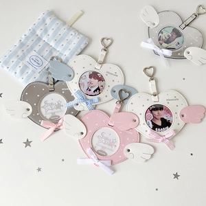 Macro detail of heart-shaped PU photo card holders with angel wings and metal hooks