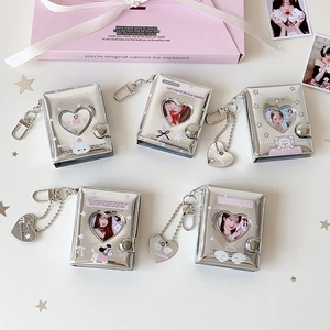 Silver mini photo album keychains with heart cutouts and lobster clasps on white background