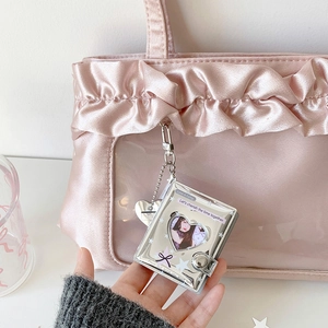 Detail of silver heart cutout mini photo album with metal chain and charm