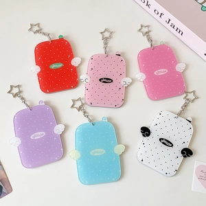 Close-up of colorful acrylic photocard holders with angel wings and star keychains