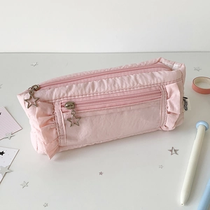 Detail of pink pleated pencil case featuring ruffled edges and star-shaped silver zippers