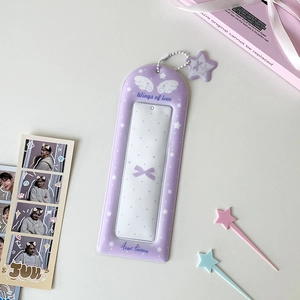 Détail du porte-carte en peluche violette avec ailes d'ange et pendentif étoile