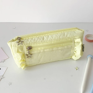 Close-up of a light yellow pleated pencil case with ruffle edges and star zipper