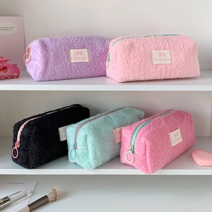 Detailed view of plush pastel pencil cases on white shelves featuring Lucky gate woven labels