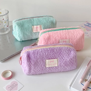 Detailed macro view of soft fluffy pencil cases in pastel mint, pink, and lavender colors