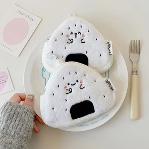 Dettaglio di simpatici portamonete in peluche a forma di onigiri su un piatto decorato