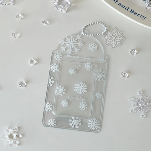 Close-up of transparent acrylic card holder with white snowflake patterns and bead chain