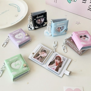 Dettaglio di mini album fotografici a forma di cuore con portachiavi argento in vari colori