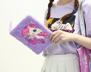 Close-up of purple plush unicorn notebook with soft faux fur cover and lined inner pages